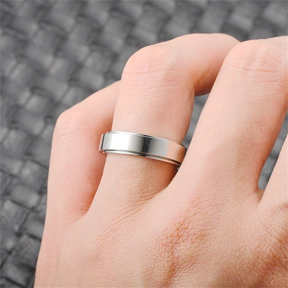A close-up of a hand wearing a silver stainless steel anxiety spinner ring.