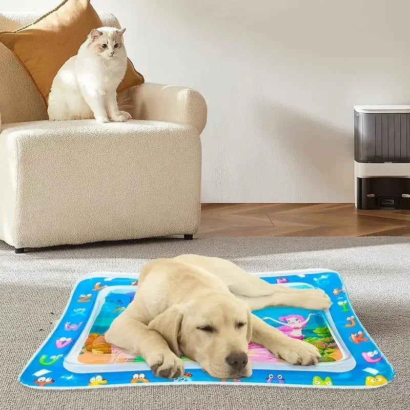 A yellow Labrador puppy is lying on a blue inflatable water play mat with colorful toys.