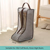 A black and white patterned waterproof boot storage bag with a handle, shown next to a wooden frame.