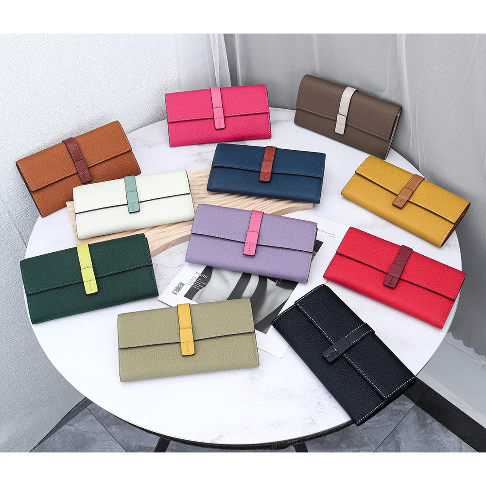 A collection of women's cowhide leather bifold wallets in various colors and shades displayed on a white table.