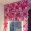 A vibrant pink silk rose flower wall panel used as a backdrop for weddings and events.