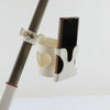 A white cup holder and phone mount attaches to a stroller bar, holding a smartphone.