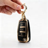 A hand holds a gold-toned protective TPU key fob cover for an Audi flip key.