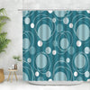 A teal fabric shower curtain featuring a geometric pattern of white circles and curved lines.