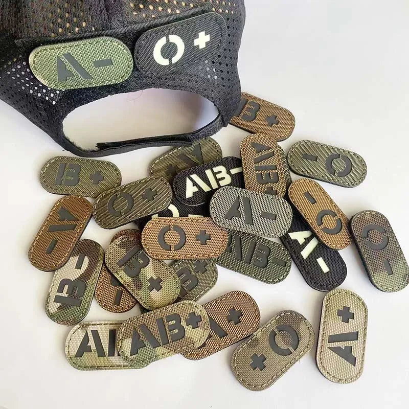 A collection of reflective glow-in-the-dark blood type tactical patches with hook and loop backing