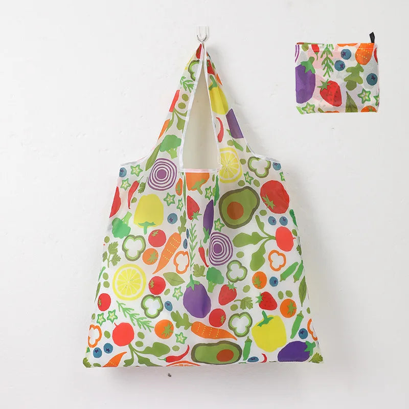 A reusable shopping tote bag featuring a colorful pattern of various fruits and vegetables.