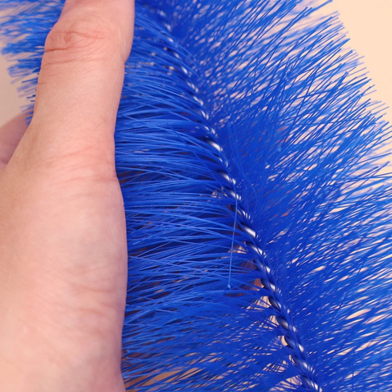 A hand holds a bright blue bendable fan duster brush with long bristles.