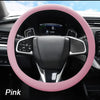 Pink soft silicone steering wheel cover installed in a car interior.
