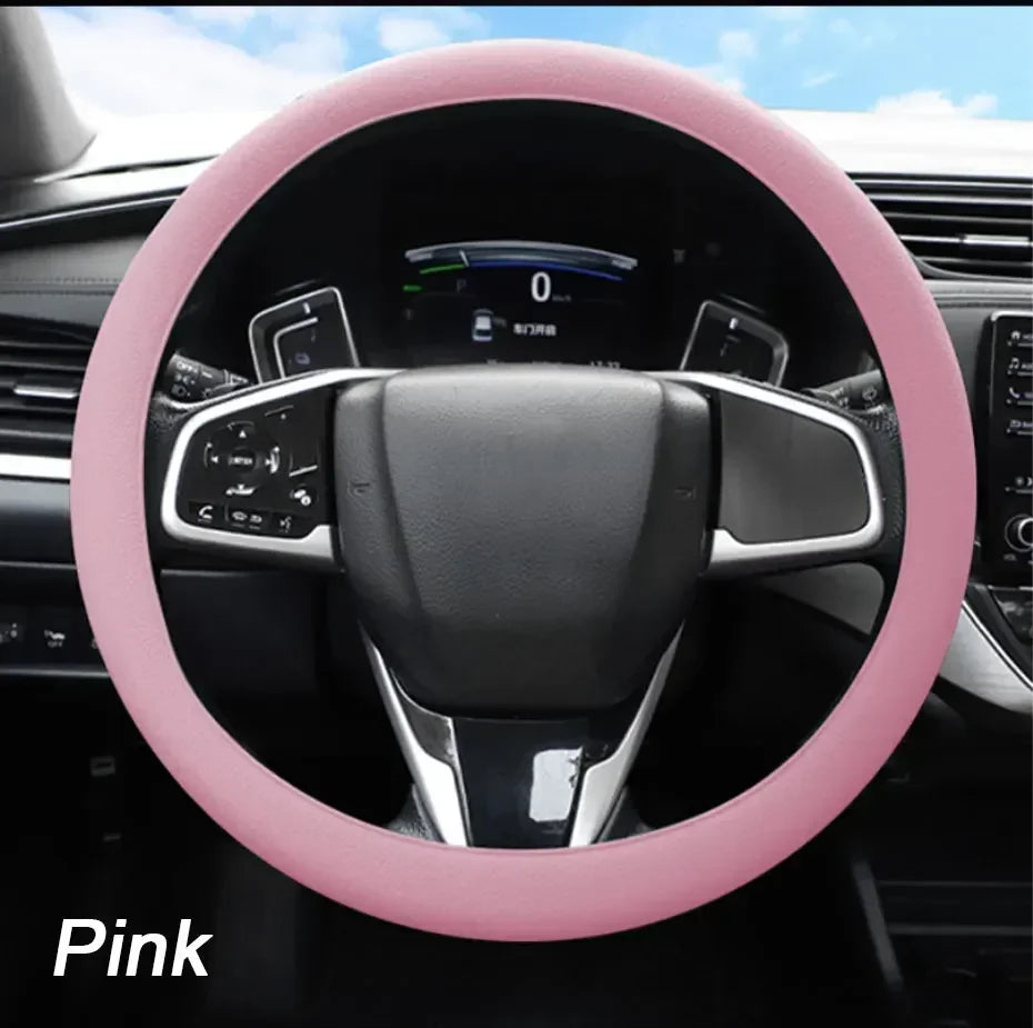 Pink soft silicone steering wheel cover installed in a car interior.