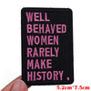 A black embroidered patch with pink text that reads Well Behaved Women Rarely Make History.