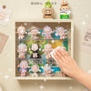 A wall-mounted display case featuring collectible dolls and a small potted plant.