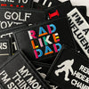 A collection of black embroidered iron-on patches featuring text like RAD LIKE DAD and other humorous phrases.