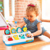 A toddler is interacting with a white and blue pop-up animal sensory toy featuring various colorful plastic animals.