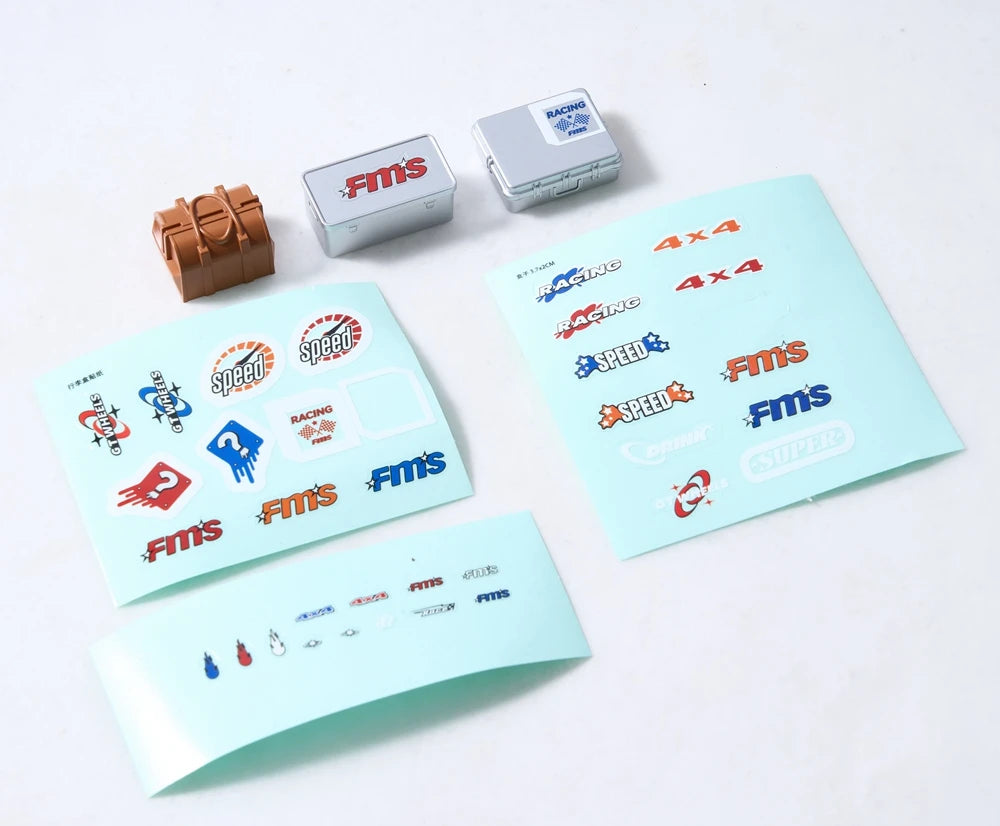 A set of RC car decorative accessories including a surfboard, kayak, and roadblocks, along with various FMS components.
