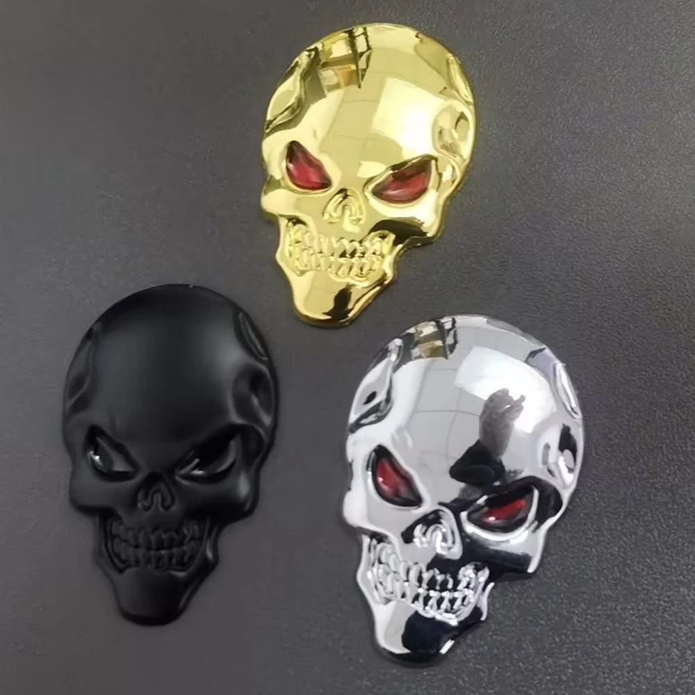 Three skull emblems in gold, black, and chrome silver metal finish.