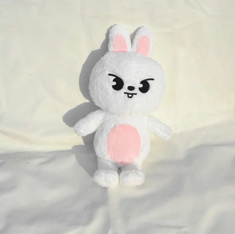 A white rabbit plush doll with pink accents sitting on a light background.