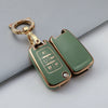 A gold-toned TPU key fob cover with a keyring is shown against a gray background.