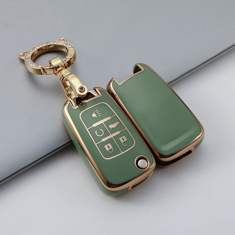 A gold-toned TPU key fob cover with a keyring is shown against a gray background.