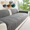 A gray anti-slip sofa cover is displayed on a light-colored sofa, with swatches showing various shades of gray and brown.