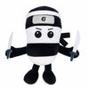 A black and white plush toy resembling a shark with a silver emblem on its forehead.