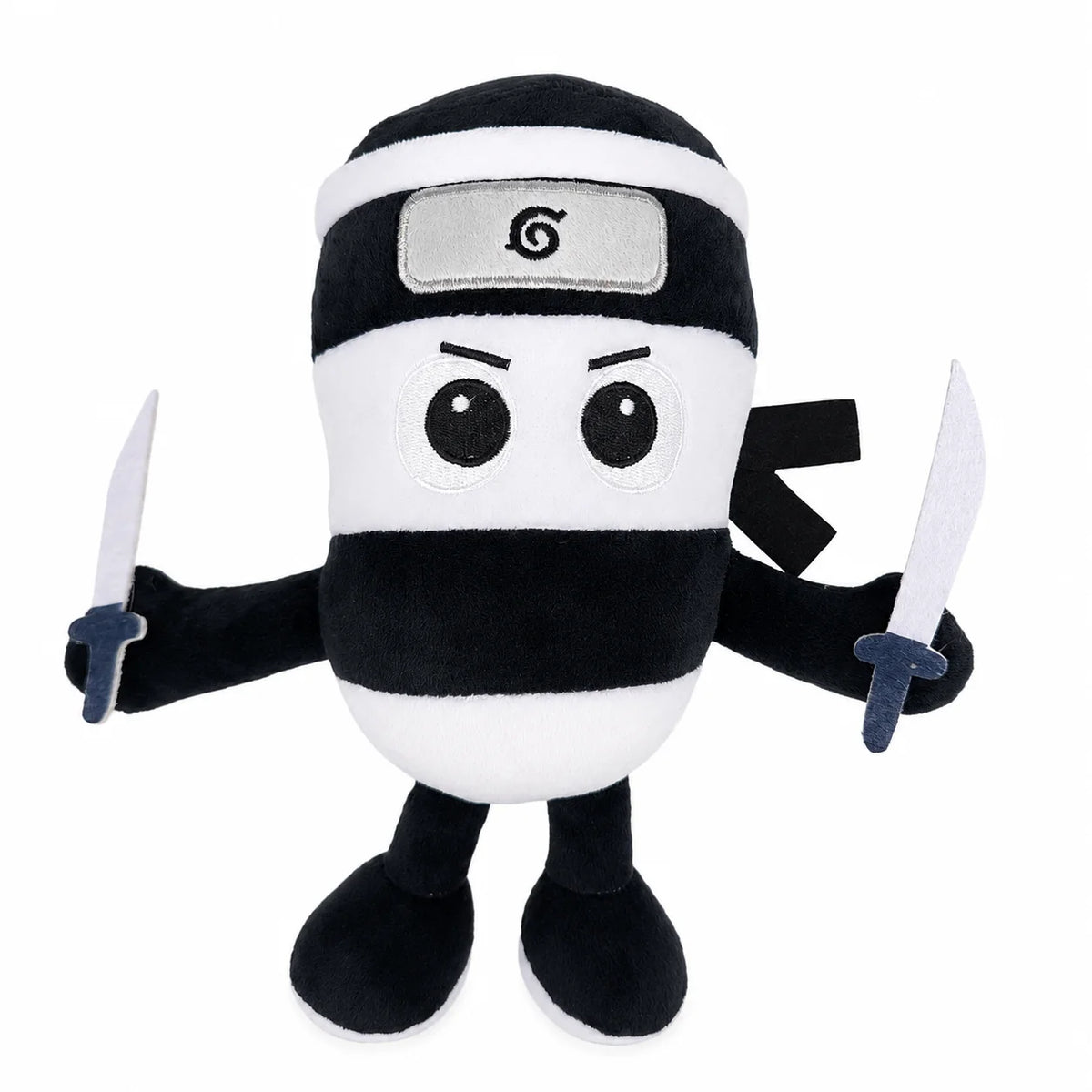 A black and white plush toy resembling a shark with a silver emblem on its forehead.