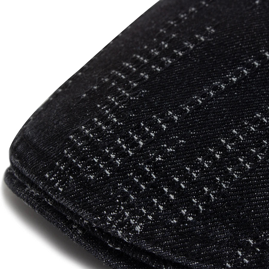 Close-up of a black vintage plaid cotton beret fabric texture.