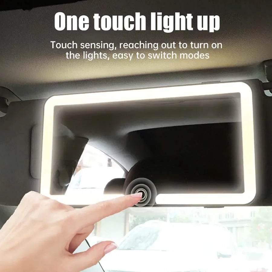 A hand touches a light strip on a car vanity mirror to turn on the lights.