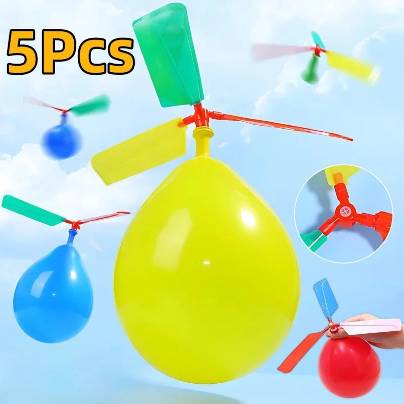 Five colorful propeller balloon helicopter toys in various colors floating against a light blue sky background.