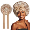 A woman models a beige satin silk sleep bonnet tied in a bow, showing the fabric and style.