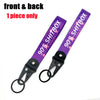 A purple and pink 90s Shitbox keychain featuring a character design with a steel clip.