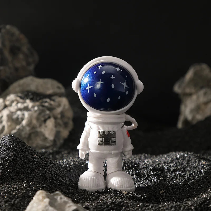 A white astronaut figurine with a blue helmet and stars is placed on a dark, textured surface.