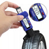A hand holds a digital tire tread depth gauge measuring the tread depth of a tire.