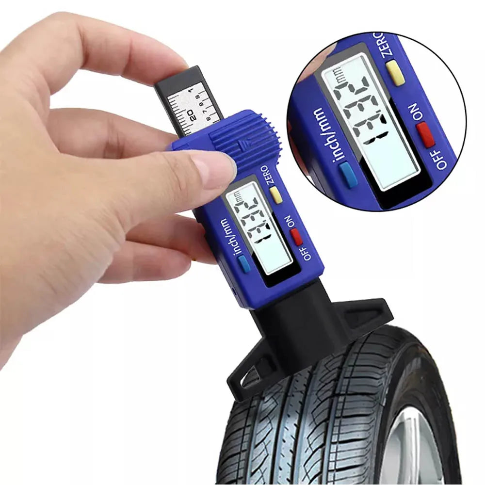 A hand holds a digital tire tread depth gauge measuring the tread depth of a tire.