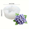 Moule en silicone blanc de 6 cm de diamètre et 2,5 cm de hauteur, à côté de fleurs violettes.