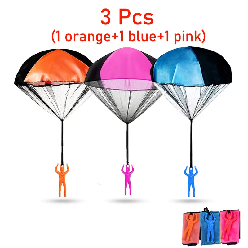 Three colorful hand-thrown parachute toys in orange, blue, and pink are displayed against a white background.