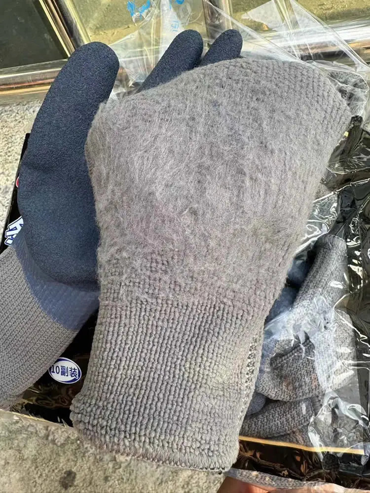 A pair of gray thermal work gloves with a dark grip are shown in clear plastic packaging.
