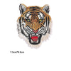 Embroidery patch of a tiger face with yellow eyes and striped fur