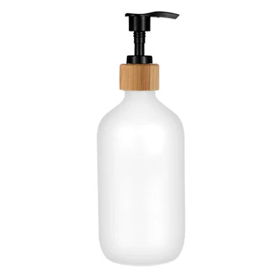 A white glass and wooden refillable soap dispenser bottle with a black pump top.