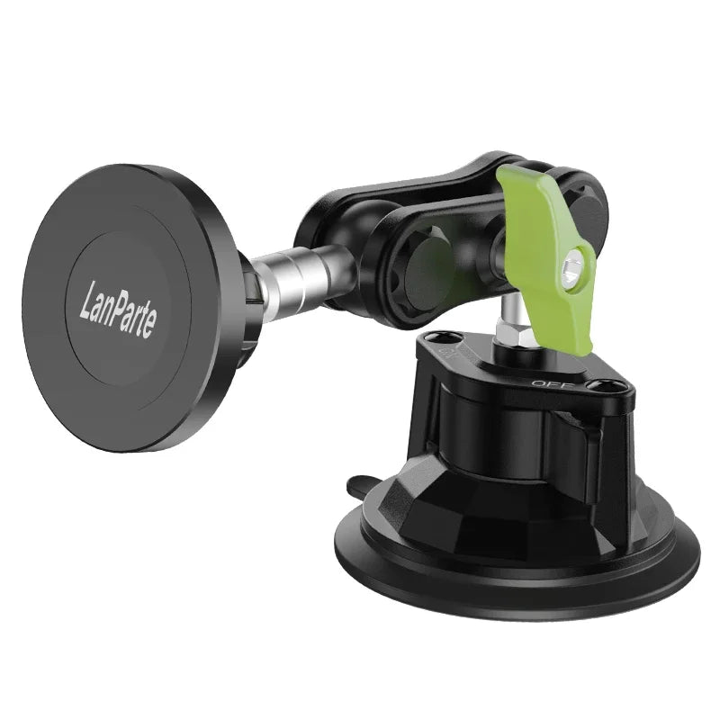 A black magnetic car phone mount with a green lever and a flat adhesive base.