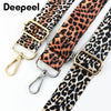 A close-up of a leopard print wide adjustable crossbody bag strap with gold hardware.