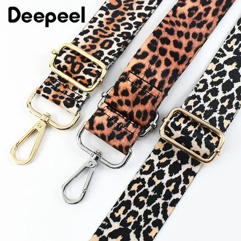 A close-up of a leopard print wide adjustable crossbody bag strap with gold hardware.
