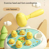 A yellow toddler hammer-pounding toy with various animal designs like a duck and frog, positioned for exercise.