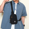 A person wearing a light blue shirt is holding a black water-resistant nylon chest sling bag.