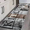 A long kitchen mat featuring black lettering and a dog lying on the mat against a light wood floor.