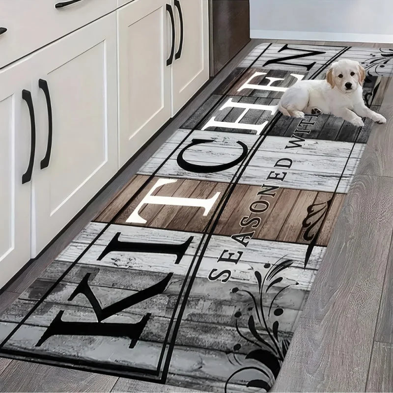 A long kitchen mat featuring black lettering and a dog lying on the mat against a light wood floor.