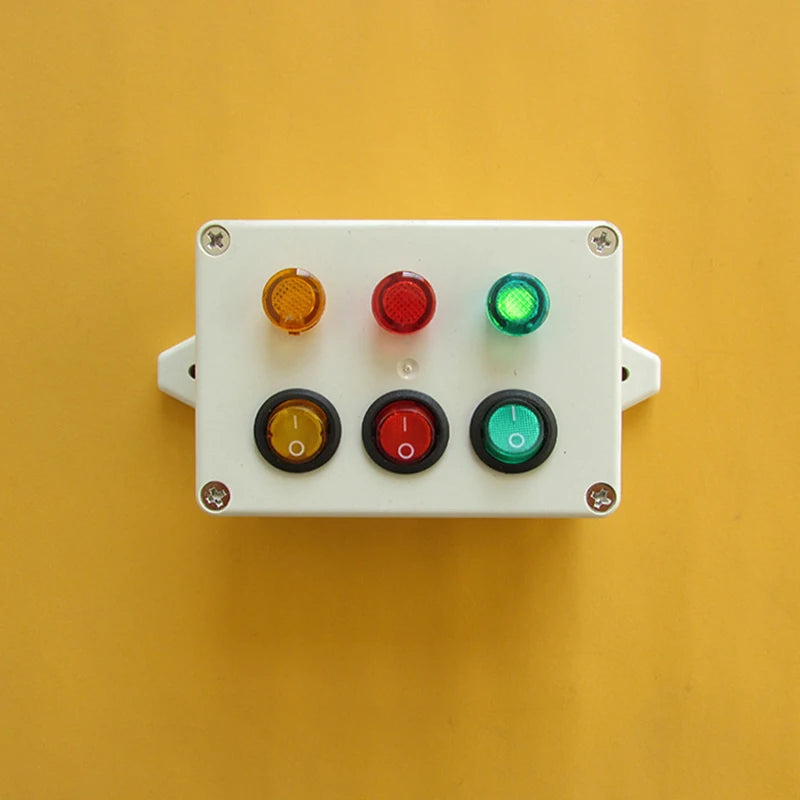 A white plastic board with six colored buttons and switches mounted on a yellow background.