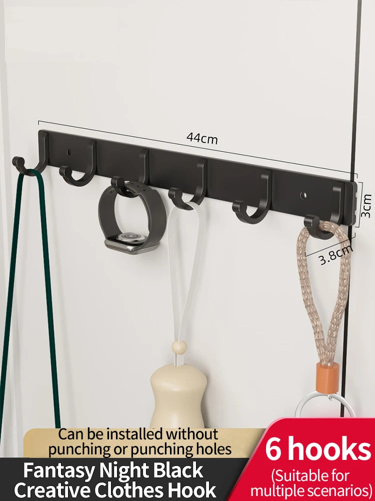 Black fantasy night clothes hooks with adhesive backing installed on a white wall