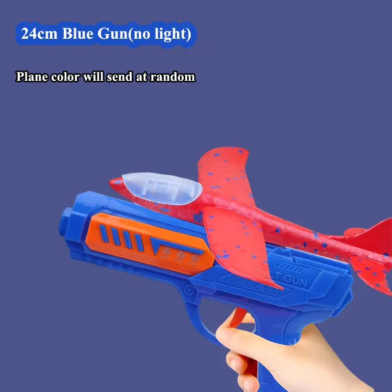 A blue foam plane launcher toy with red accents is being held by a hand against a dark background.