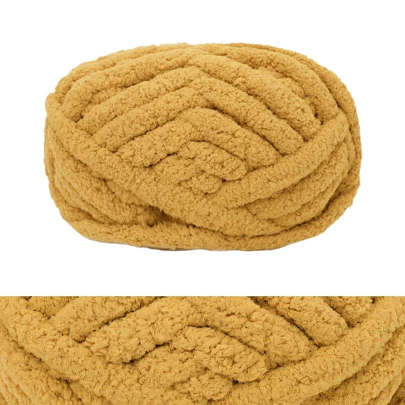 A ball of chunky chenille yarn in a golden tan color.