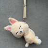A light yellow plush toy resembling a dog or puppy with closed eyes and pink inner ears hanging from a strap.
